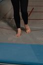 Person in Black Pants Standing on Brown Floor