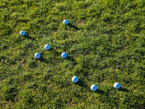 White Golf Balls on Green Grass
