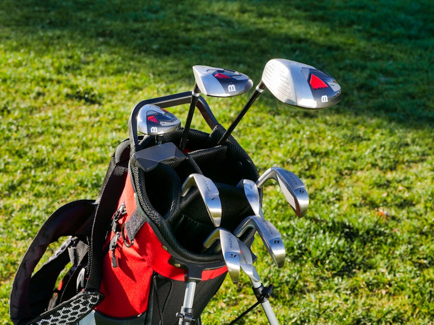 A detailed shot of golf clubs in a bag outdoors on a sunny field, perfect for sports enthusiasts.