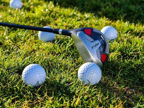 Free Golf Balls and Golf Club on Grass Stock Photo