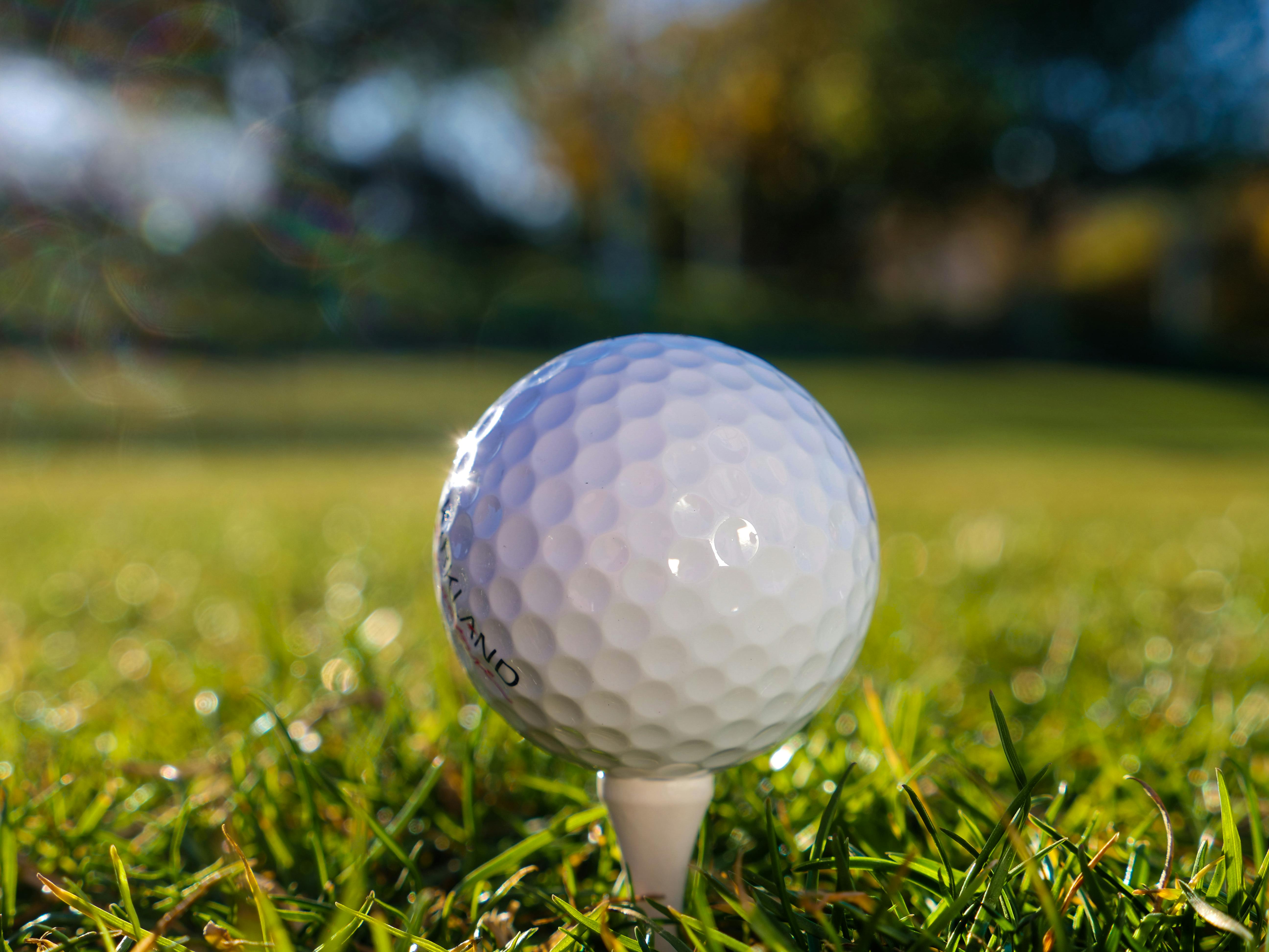 Golf club hitting ball on field · Free Stock Photo
