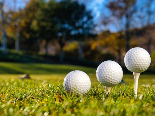 Golf Balls on Tees in the Green Grass