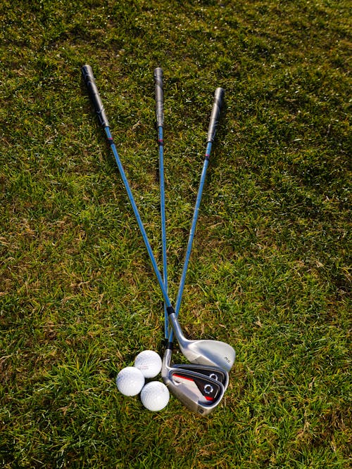 Free Three Golf Balls Beside Three Golf Clubs Stock Photo