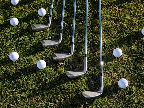 Silver Golf Clubs and Golf Balls on Grass
