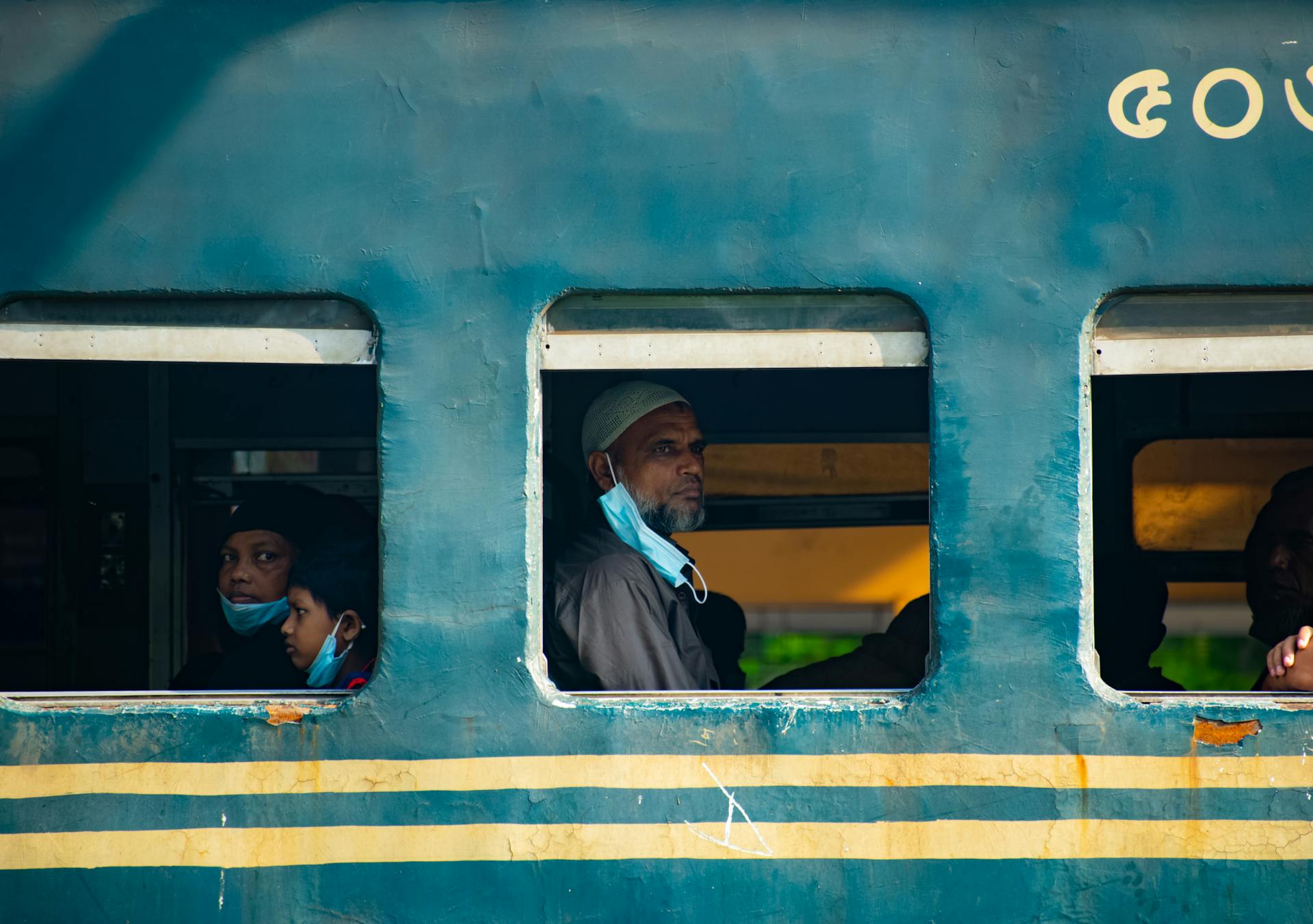 People traveling in a train in Rajshahi Division, Bangladesh. Captured from outside the train window.