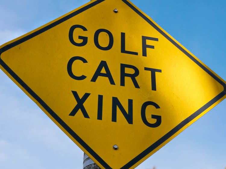 A Yellow Road Sign With Golf Cart Xing