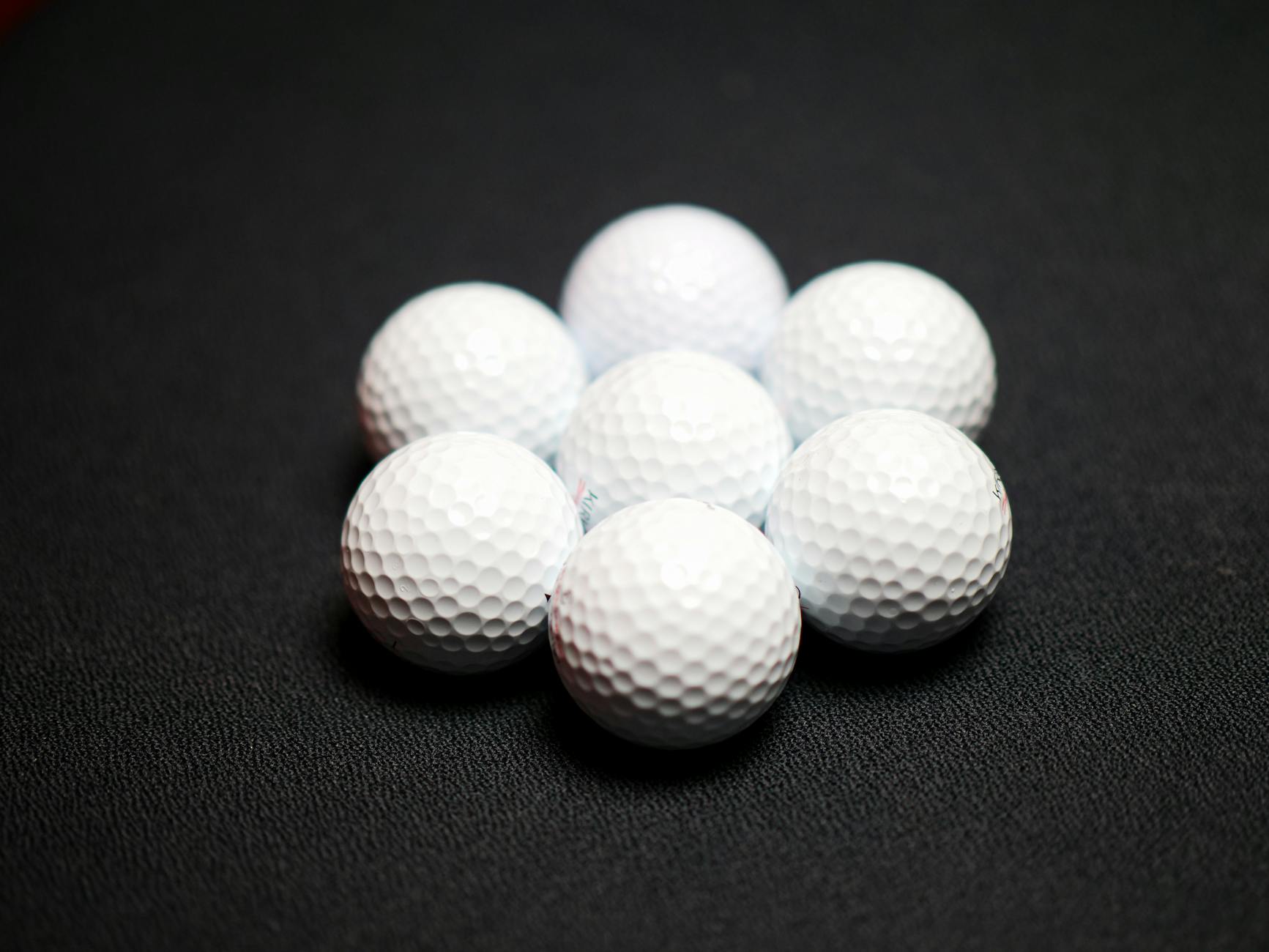 Set of golf balls on black background