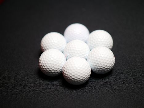 Set of golf balls on black background