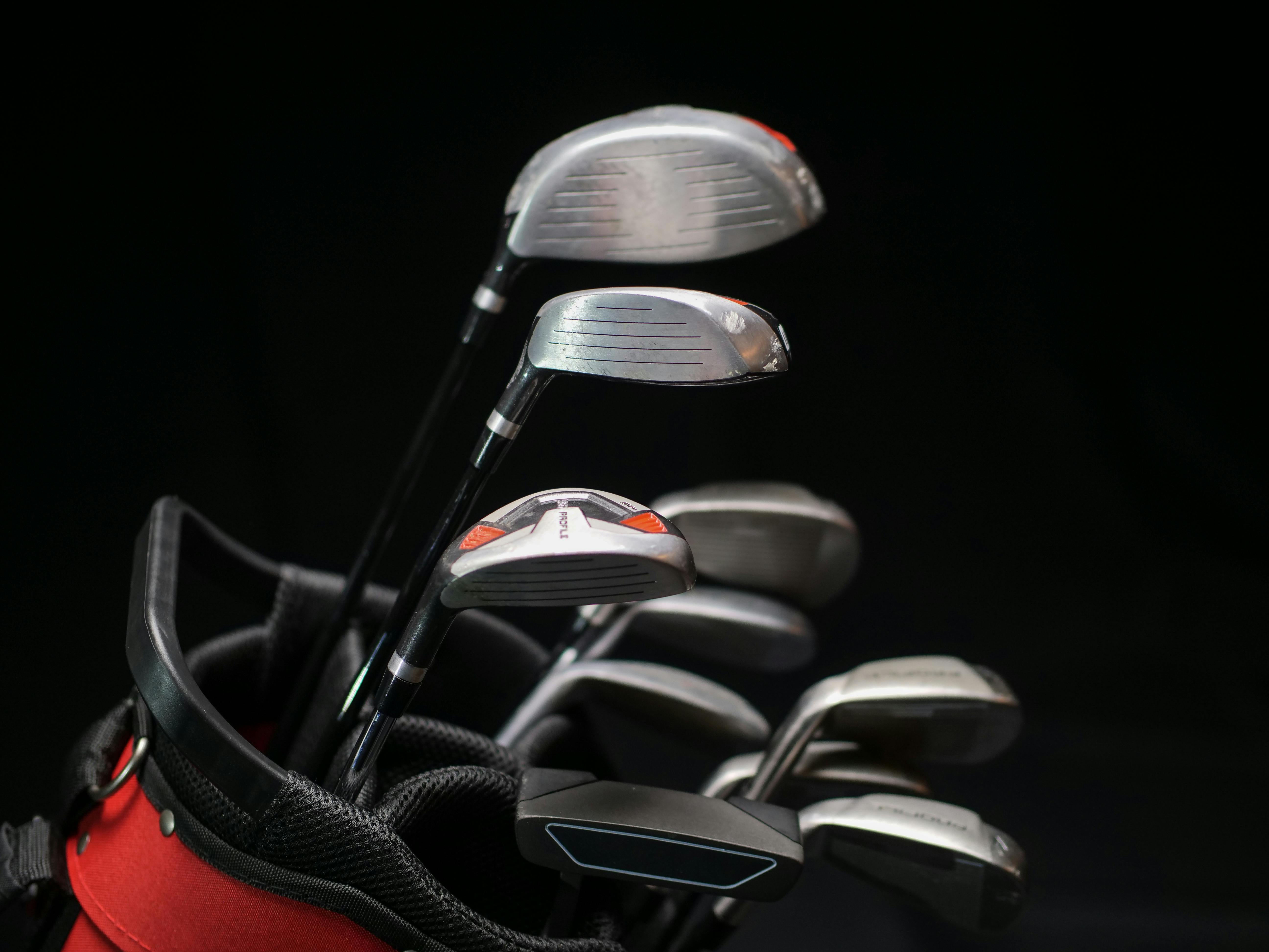 A close-up image featuring a set of golf clubs including irons, driver, and putter in a bag.