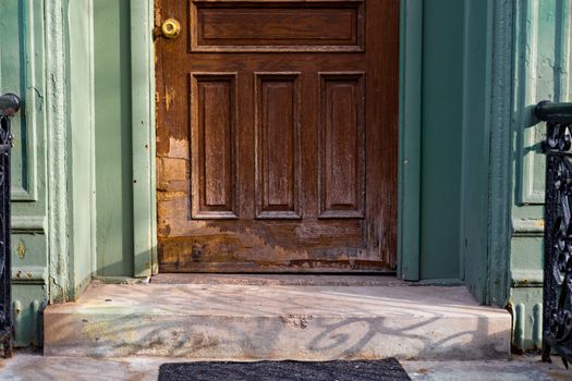 A close-up view of an old wooden door with peeling paint and vintage charm.