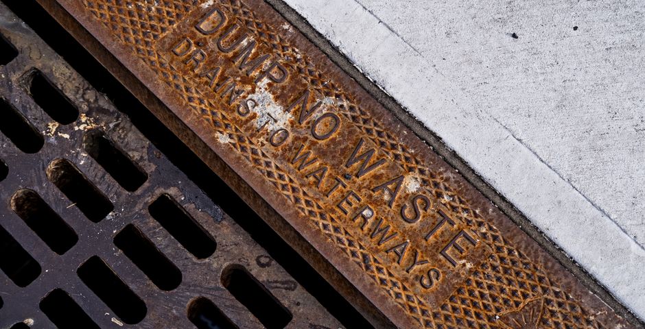 A rusty street drainage grate — the front door for American cockroaches in Malaysia