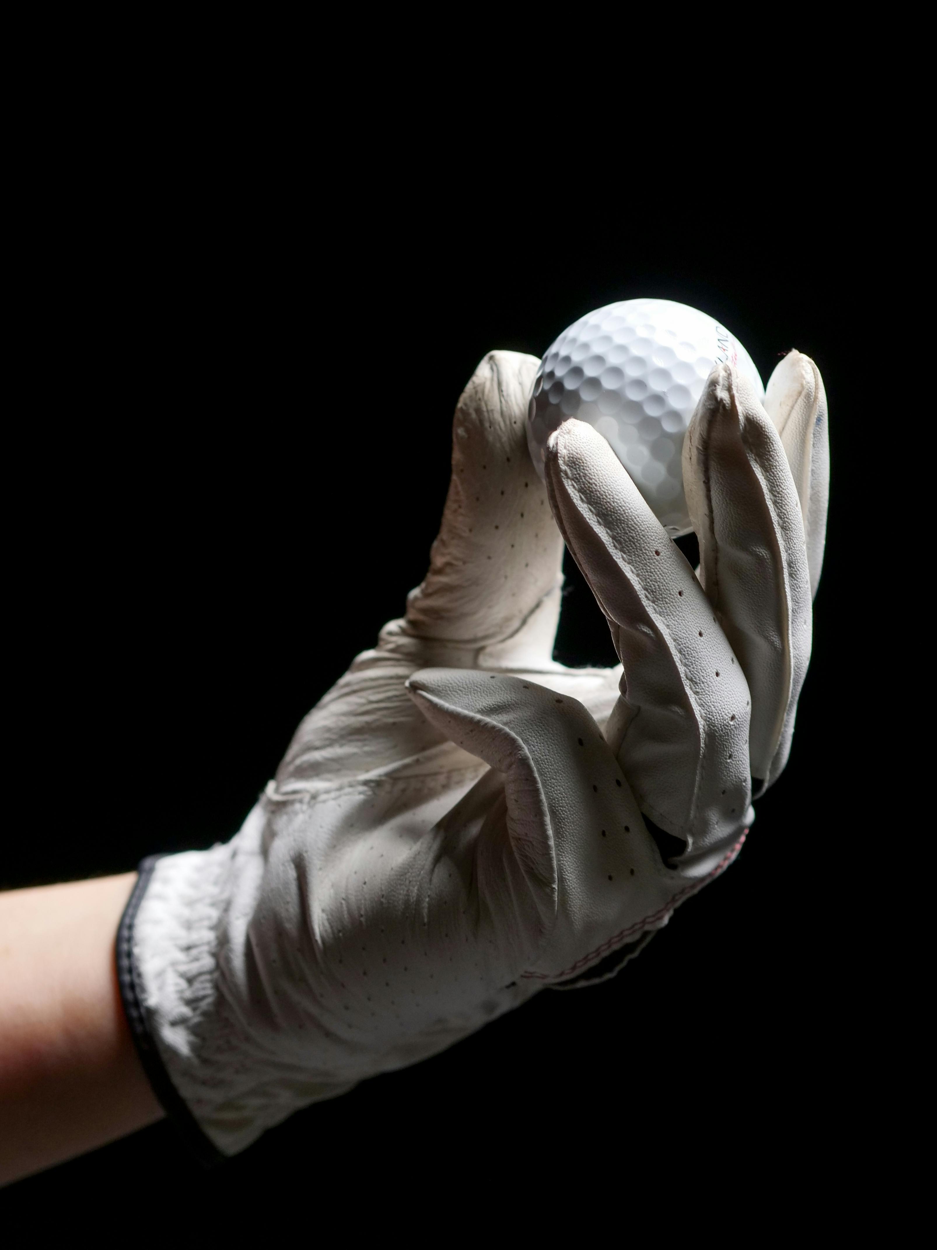 a person holding a golf ball