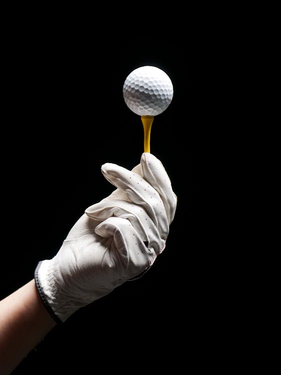 Person Wearing Gloves Holding Golf Tee With Ball 