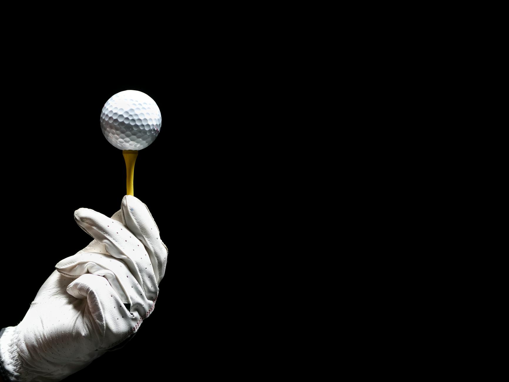 A Person Holding a Golf Tee with Golf Ball