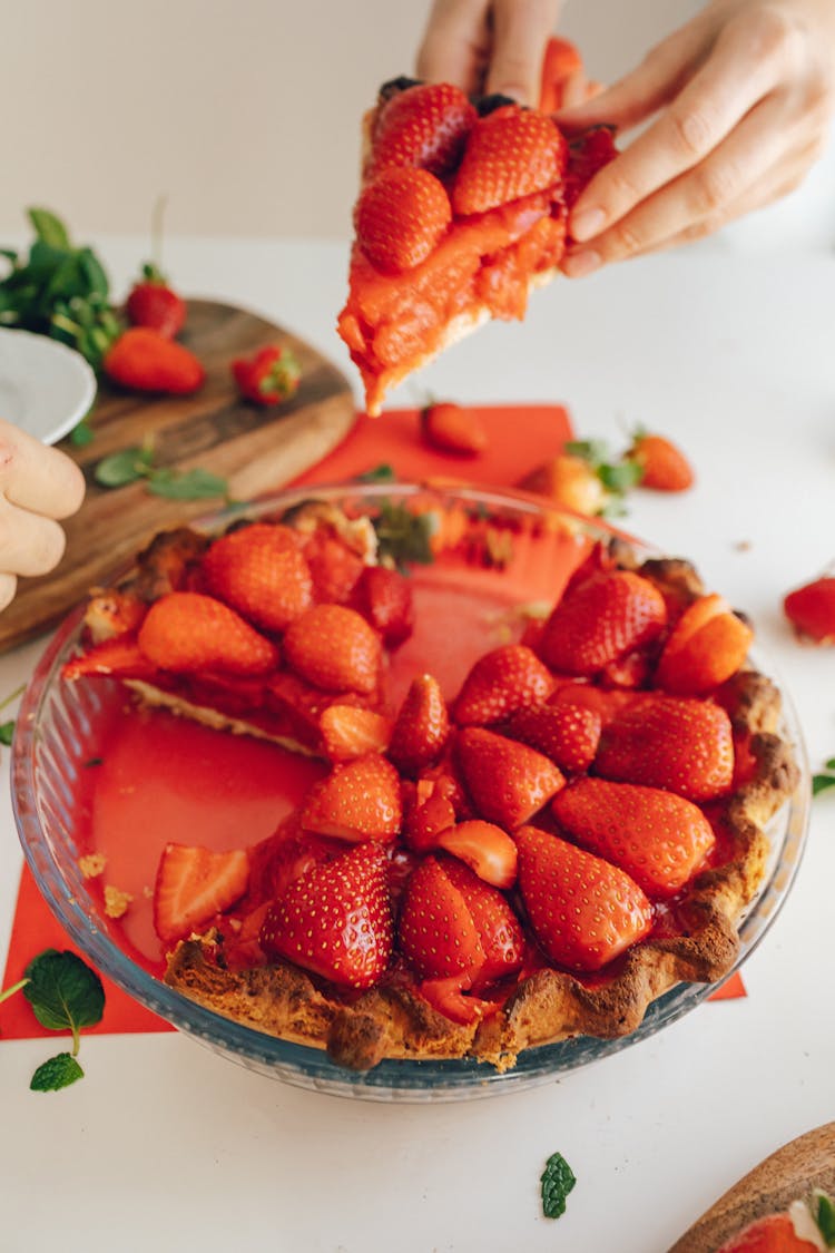 Close-up Of A Person Putting A Slice Of Strawberry Pie On Another Persons Plate 