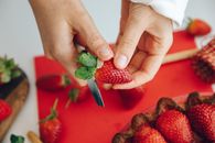 Person Cutting Strawberry Calyx