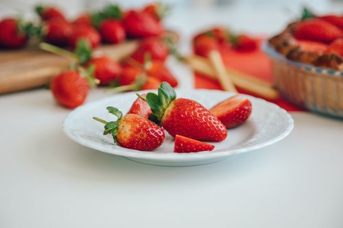 Free Close-up of ripe strawberries on a ceramic plate with a blurred background. Stock Photo
