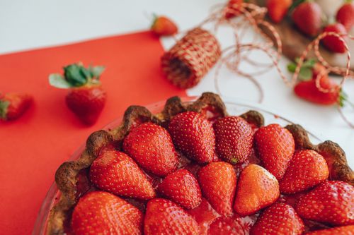 Free A delicious homemade strawberry pie on a red background, perfect for dessert lovers. Stock Photo