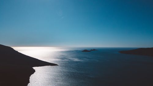 Free Peaceful ocean view with stunning blue sky and silhouetted islands at dawn. Stock Photo