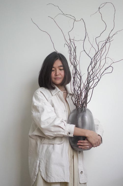 Asian woman with vase with dry decorative branches