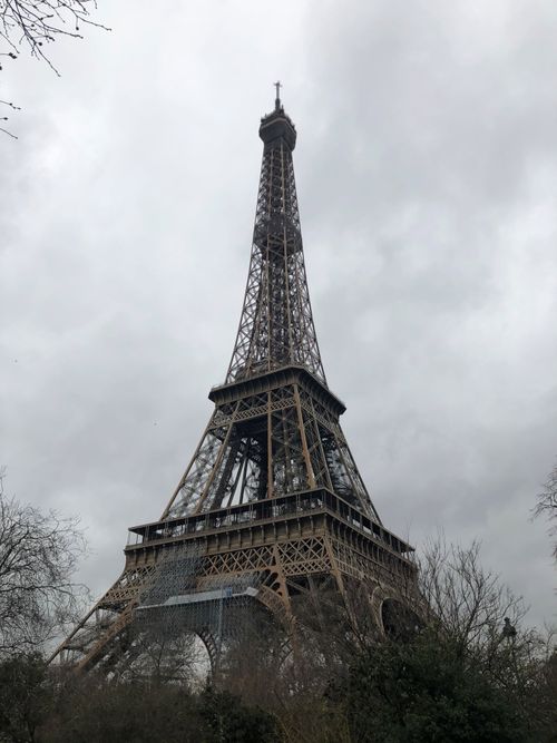 Free Low-angle view of the Eiffel Tower in Paris, France, set against a backdrop of cloudy skies. Stock Photo