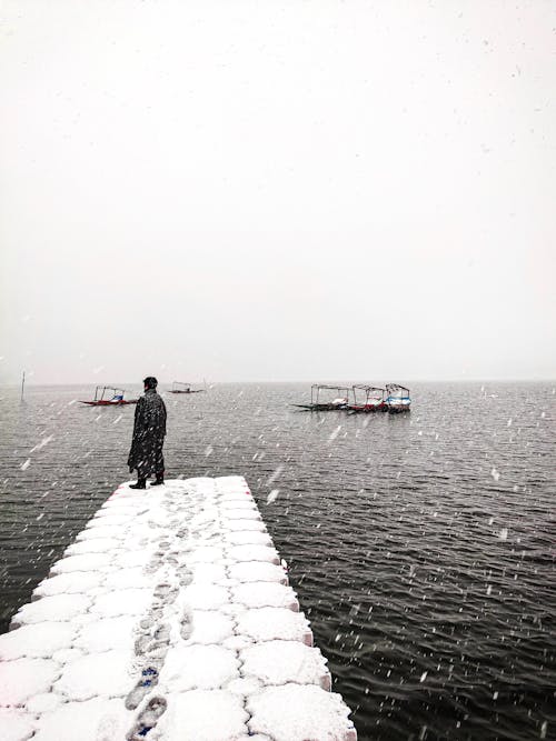 A Man Standing on the Snowy Dock