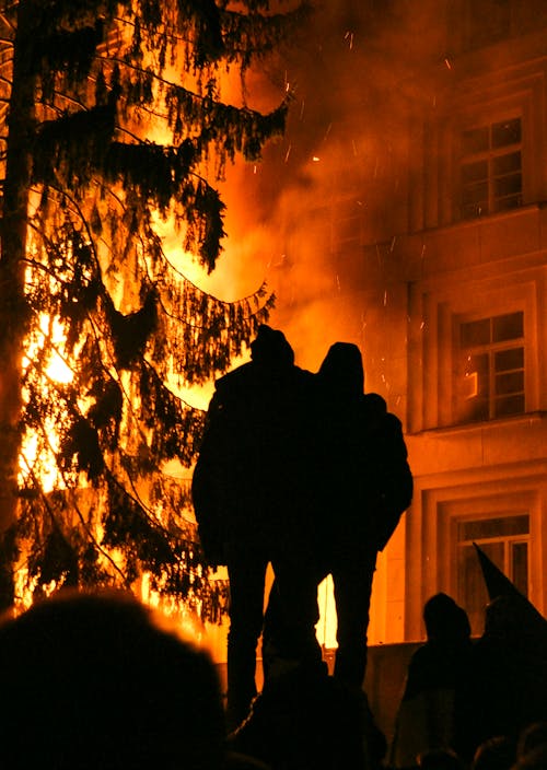 Man and Woman Standing in Front of a Fire
