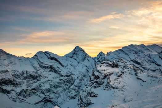 Stunning sunset view of snow-covered mountains in Lauterbrunnen, Switzerland.