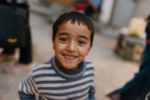 Free A cheerful young boy smiling widely in an outdoor setting, showcasing happiness and innocence. Stock Photo