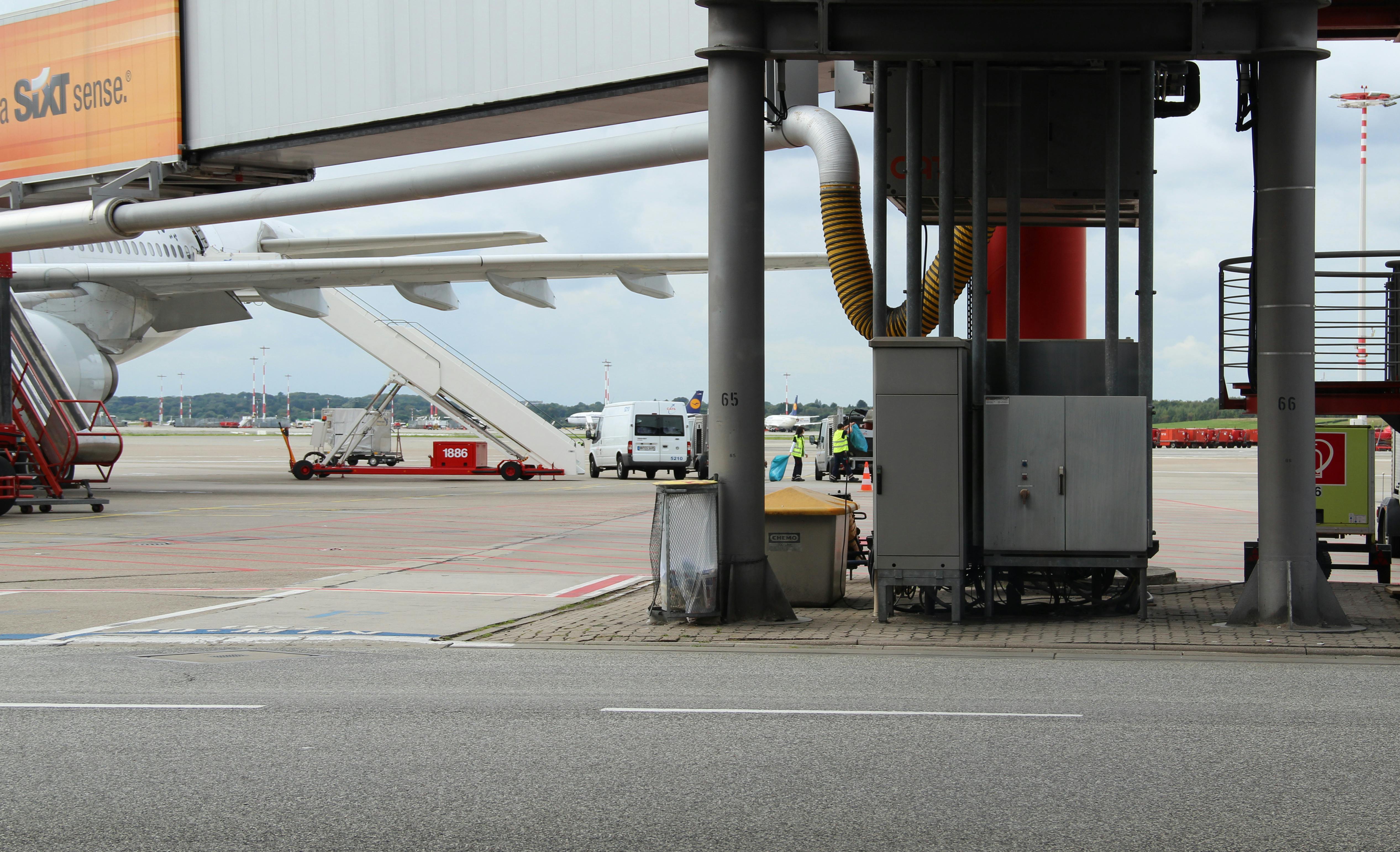 Free Airport scene depicting aircraft preparation on the tarmac with maintenance equipment. Stock Photo