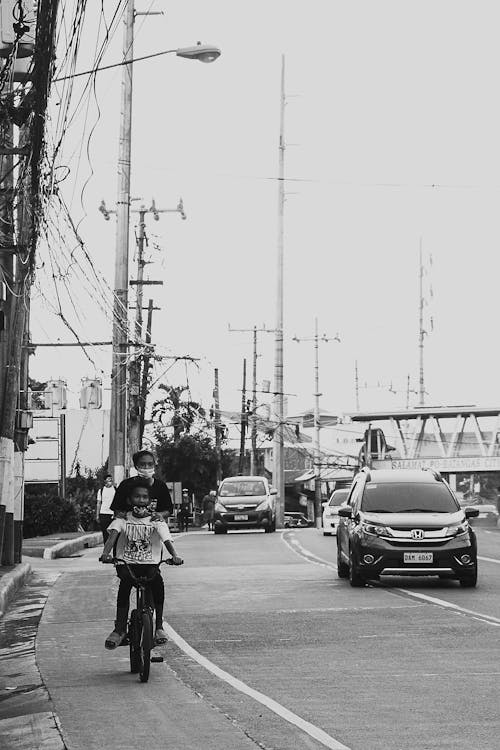 Teenagers in protective masks riding bike in city