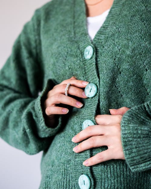 Woman in green woolen cardigan with trendy buttons