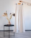 Woman with woolen stylish trousers on hanger