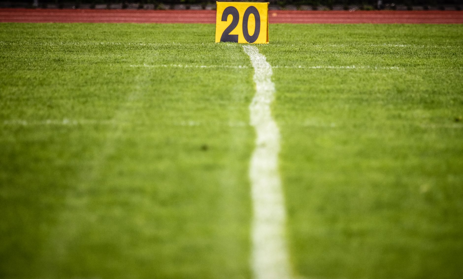 Close-up view of a football field with a 20-yard marker, showcasing vibrant green grass.