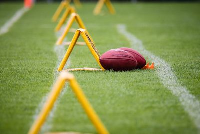 A ball resting beside training hurdles on a marked field — photo by Chris K on Pexels