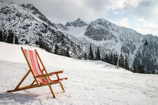 Colorful deck chair in a stunning snowy ski resort with majestic mountains in the background.