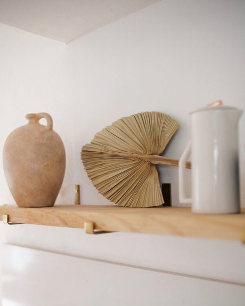 Ceramic Pots and a Dried Fan Palm on a Wooden Shelf