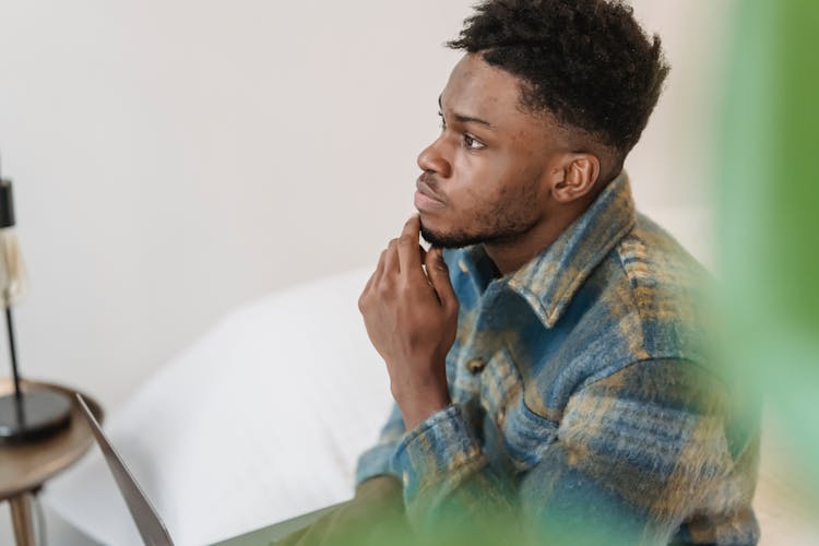 Pensive Black Man Thinking In Light Room