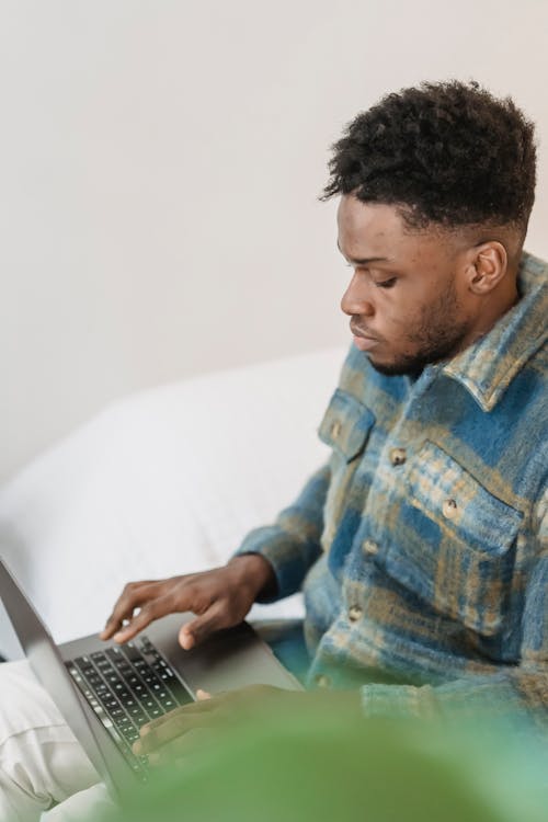 Serious black guy typing on laptop