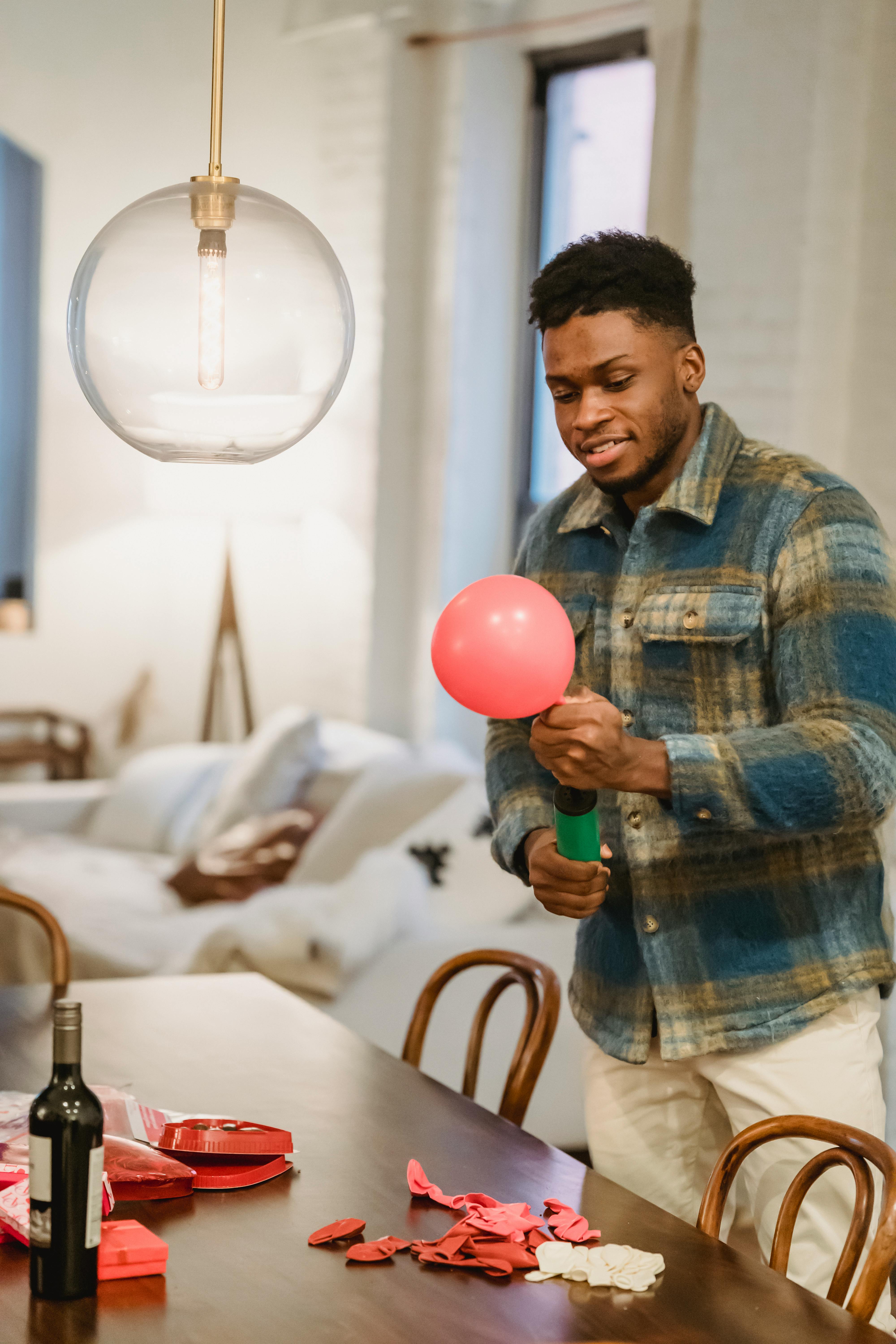 busy black guy inflate balloon with pump