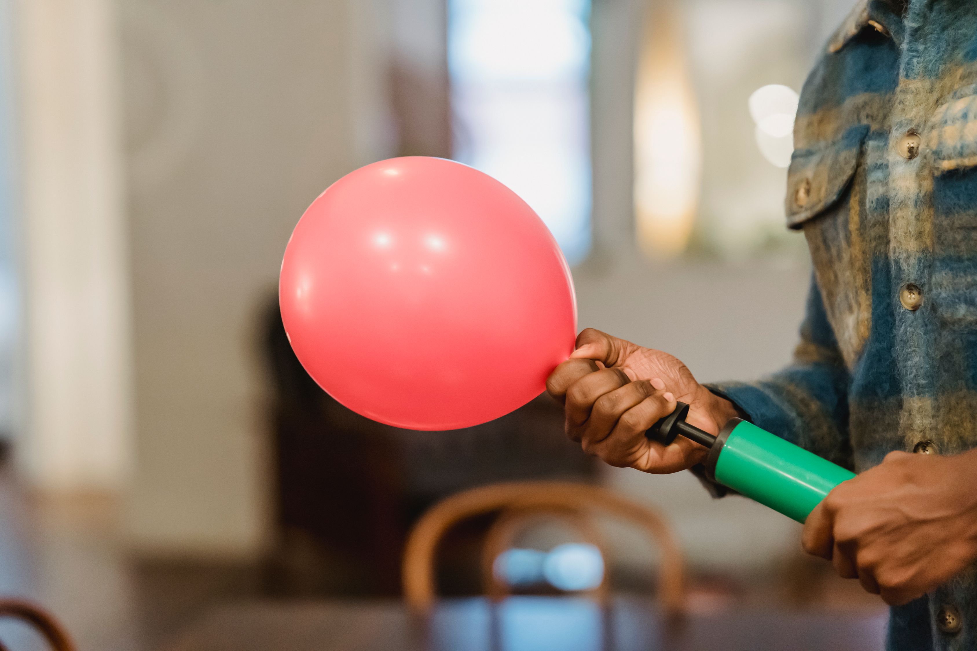 Black man inflating balloon with pump · Free Stock Photo