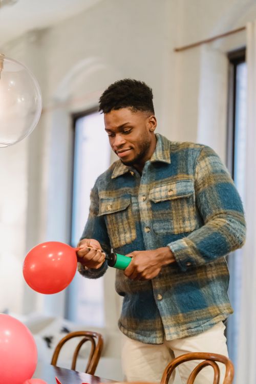 Imageman Inflating Ballon Black man inflating balloon with pump · Free Stock Photo
