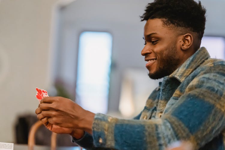 Positive Young Black Man With Heart Shaped Stickers In Hands