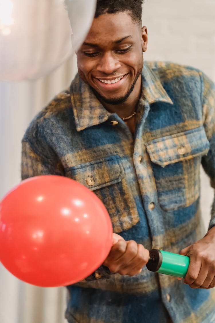 Cheerful Man Blowing Up Red Balloon