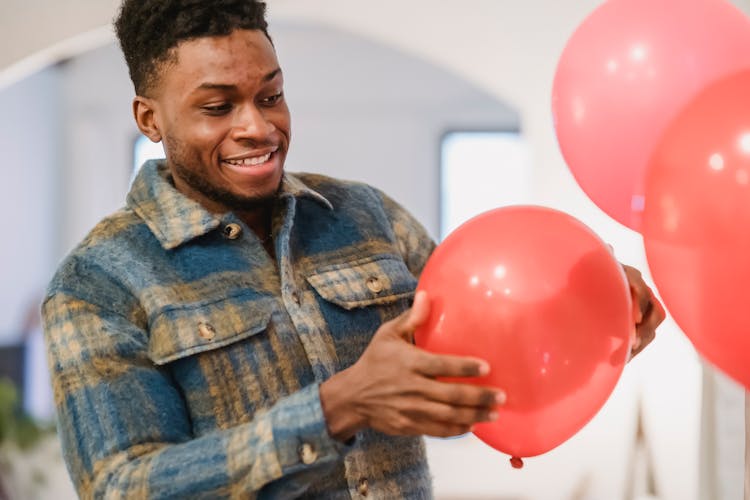 Smiling Black Man Holding Red Balloon