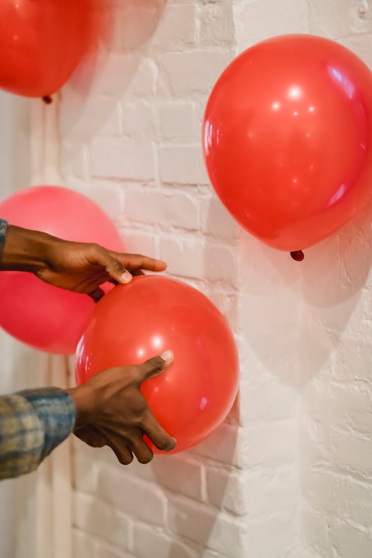 Black Man Putting Red Balloons On Wall