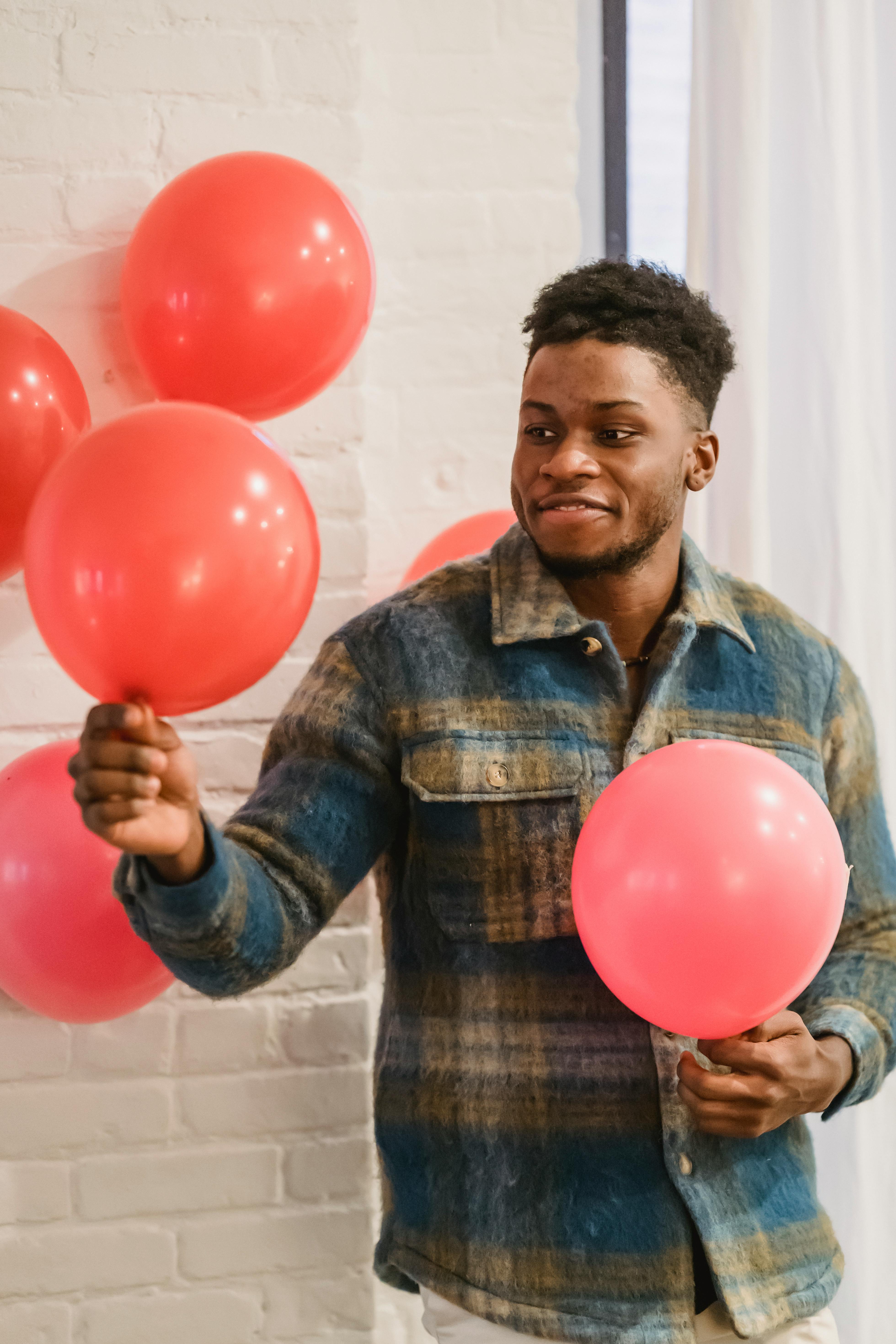 hoog Frank Uit African American man holding red balloons · Free Stock Photo