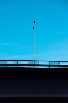 Minimalist bridge and streetlight photo with a vivid blue sky.