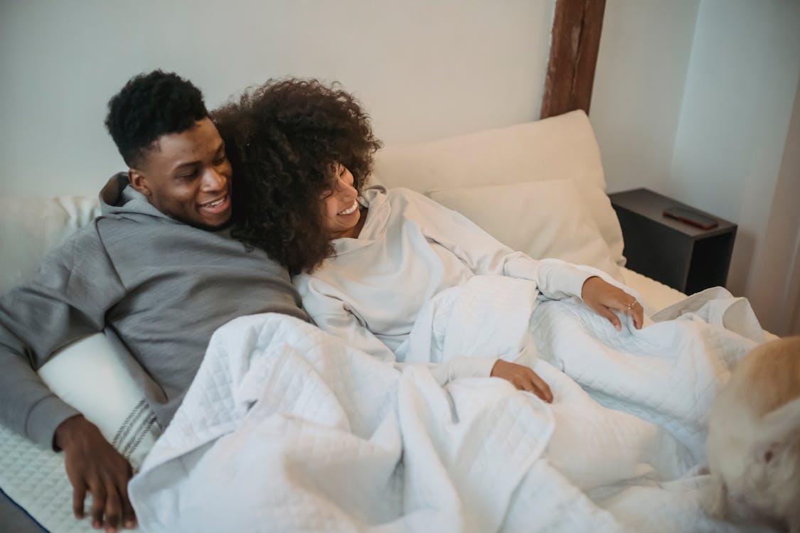 Free Loving black couple with dog on bed Stock Photo