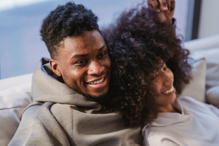 Loving Positive Black Couple Smiling And Resting On Sofa